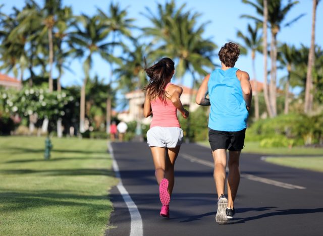 Runners athletes running training legs on road in residential neighborhood