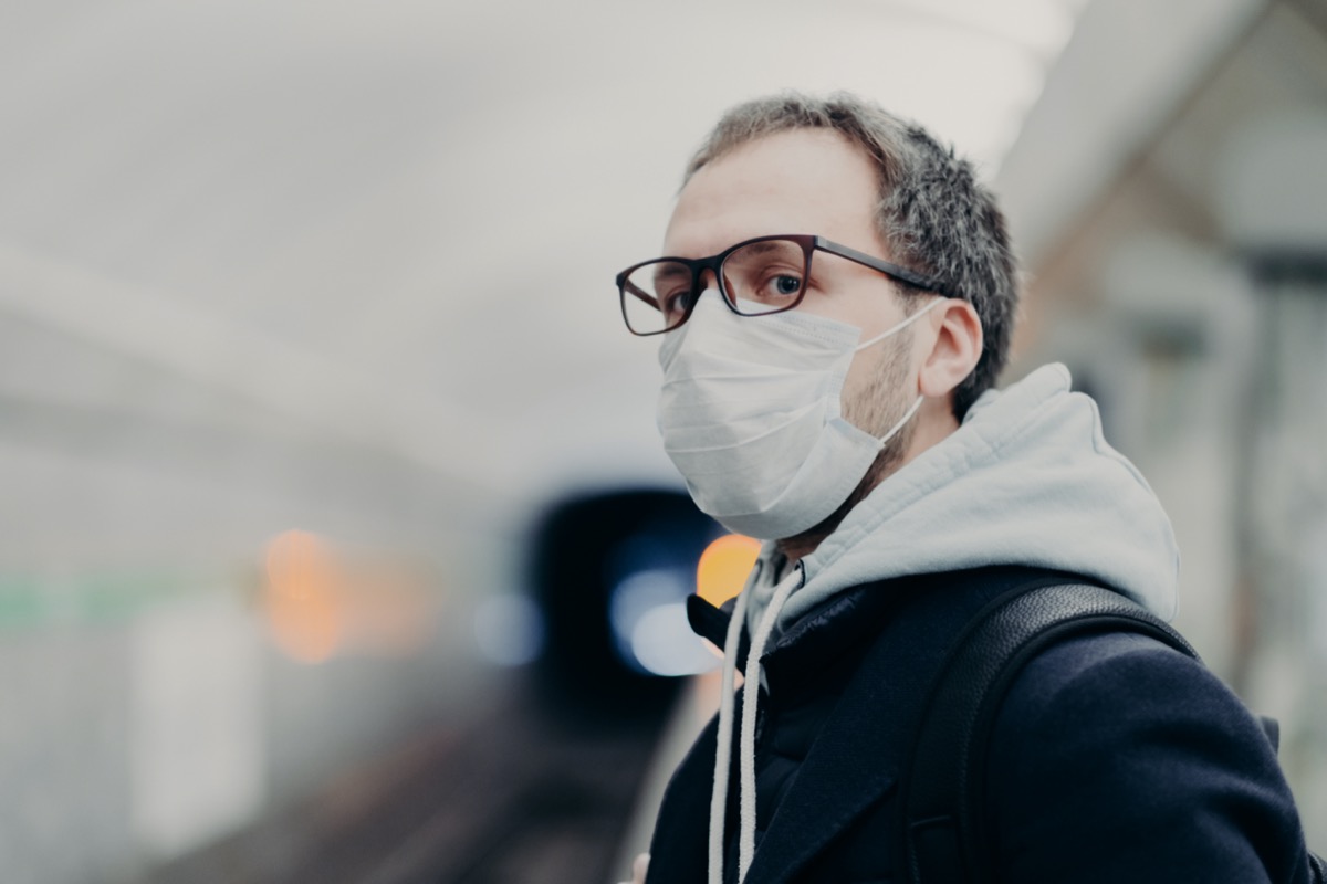 man wears medical mask against transmissible disease, travels in subway