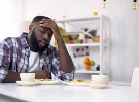 Tired African-American man having headache after hard day, feeling exhausted