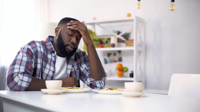 Уморен афроамериканец с главоболие след тежък ден, чувстващ се изтощен