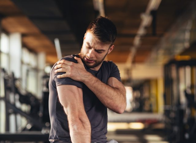 man feeling the pain in shoulder at the gym