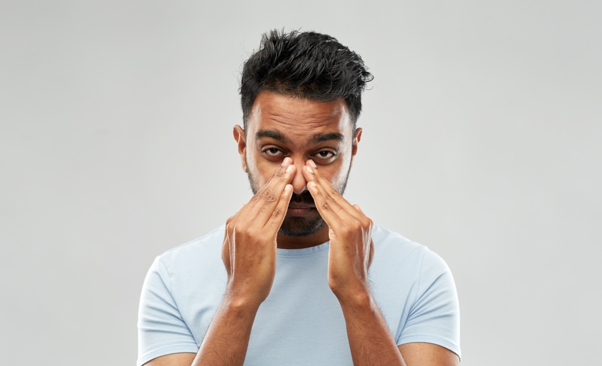 health problem and people concept - indian man rubbing nose over grey background