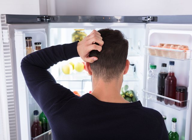 man looking at refrigerator