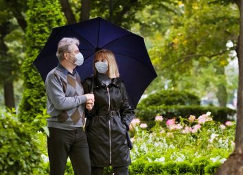 Retired couple walking in a park under quarantine during coronavirus outbreak