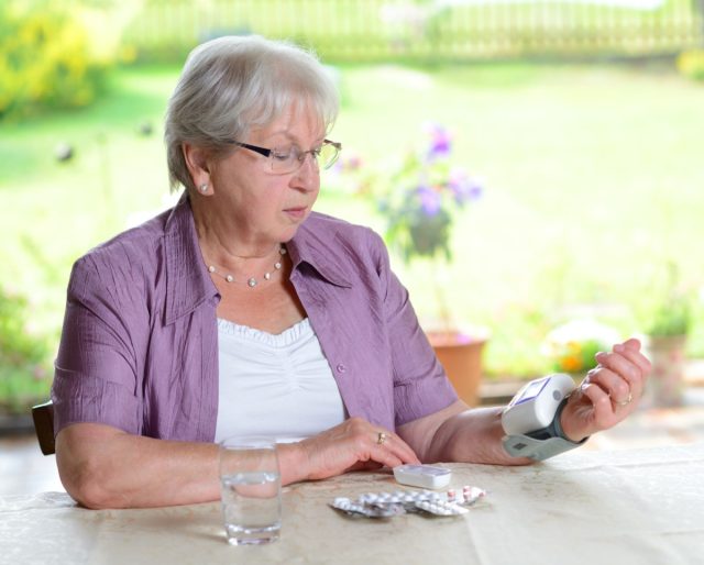 older woman is measuring blood pressure