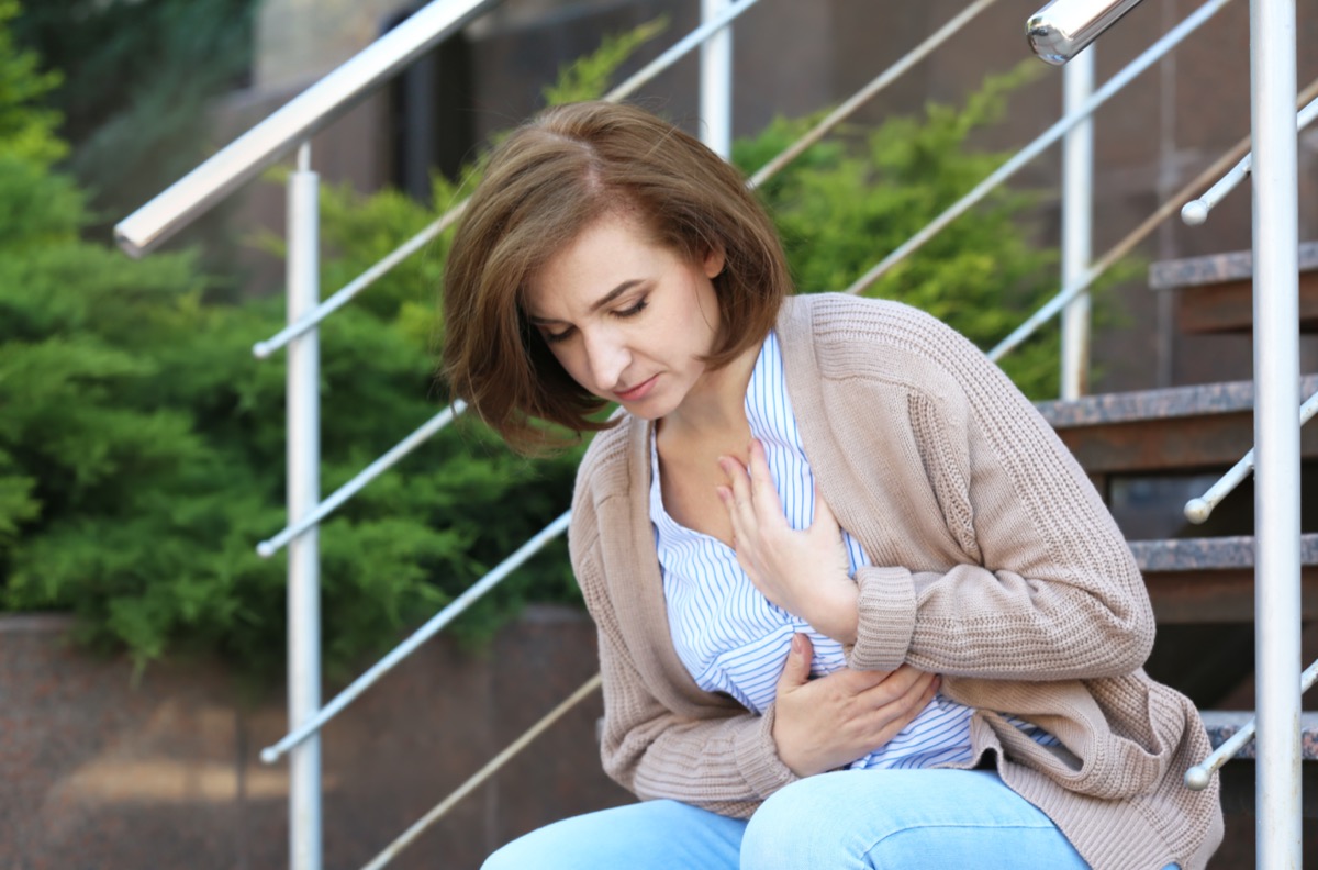 Mature woman having heart attack on stairs, outdoors