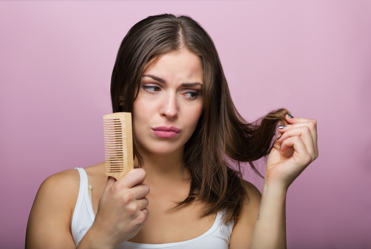 Woman brushing her hair with a wooden comb