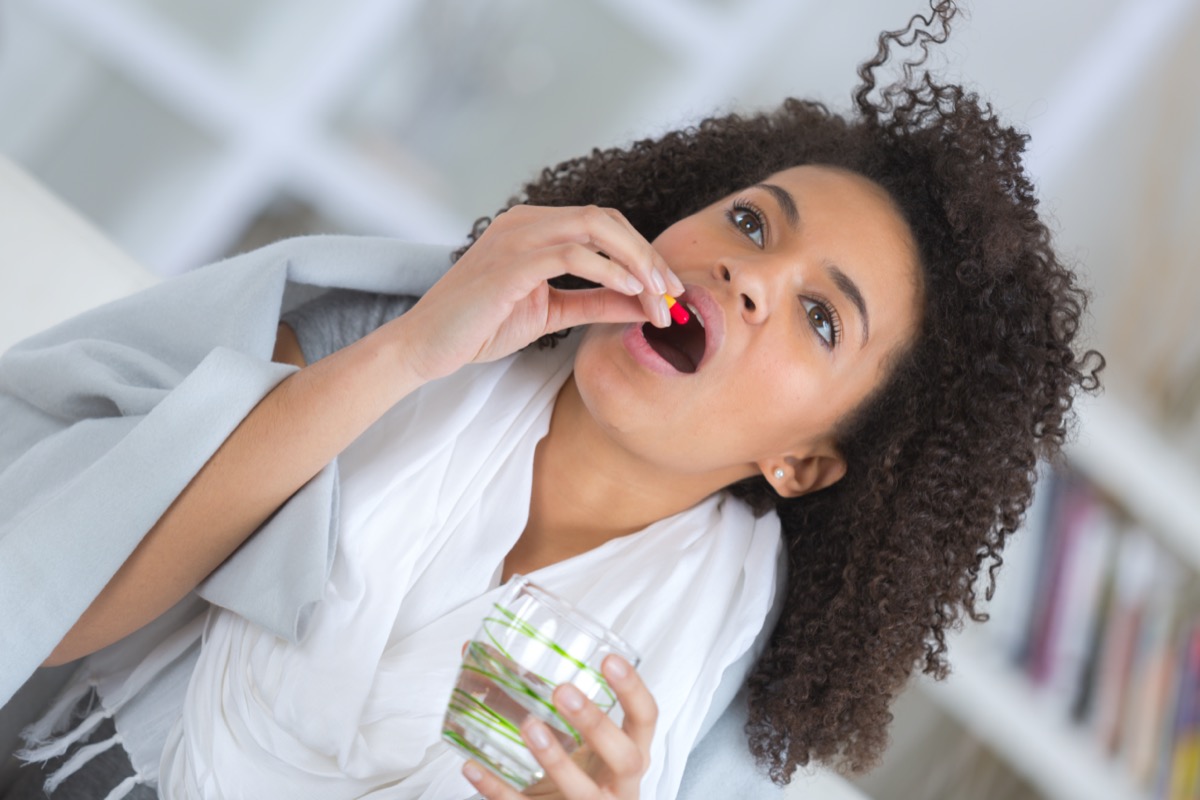 Sick woman taking pill for treatment