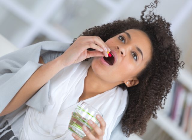 Sick woman taking pill for treatment