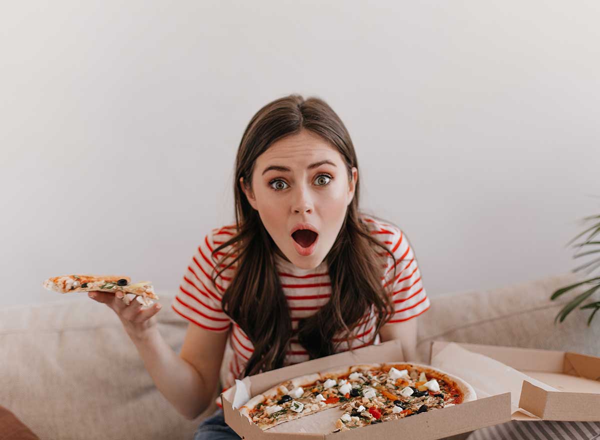 surprised woman eating pizza