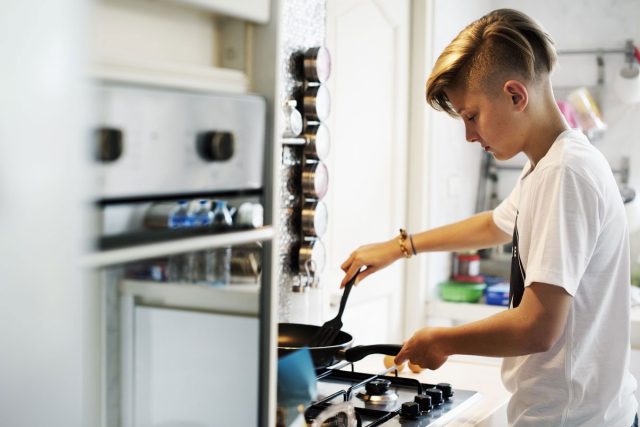 teenager cooking at stove
