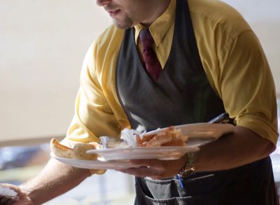 Waiter clearing table at restaurant