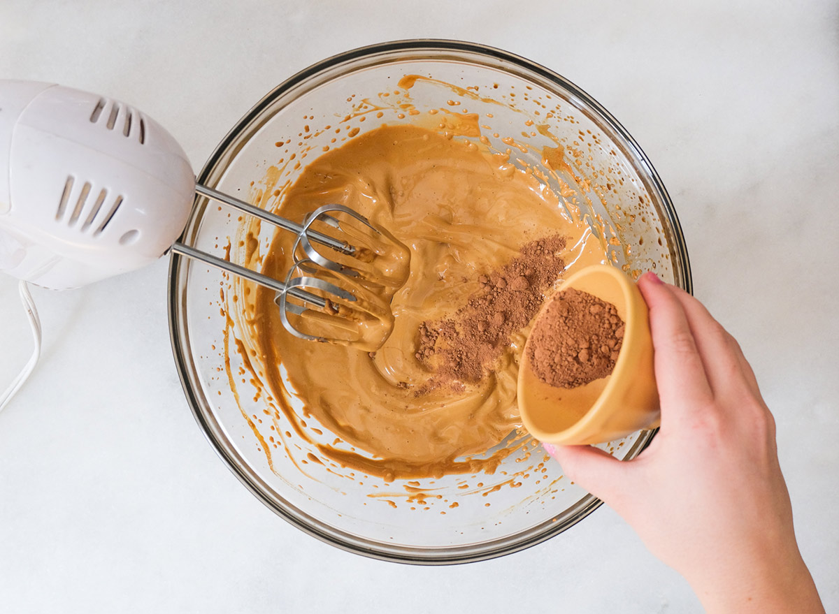 mixing cocoa powder into frothy whipped coffee