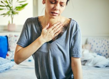 woman suffering from chest pain while sitting at home