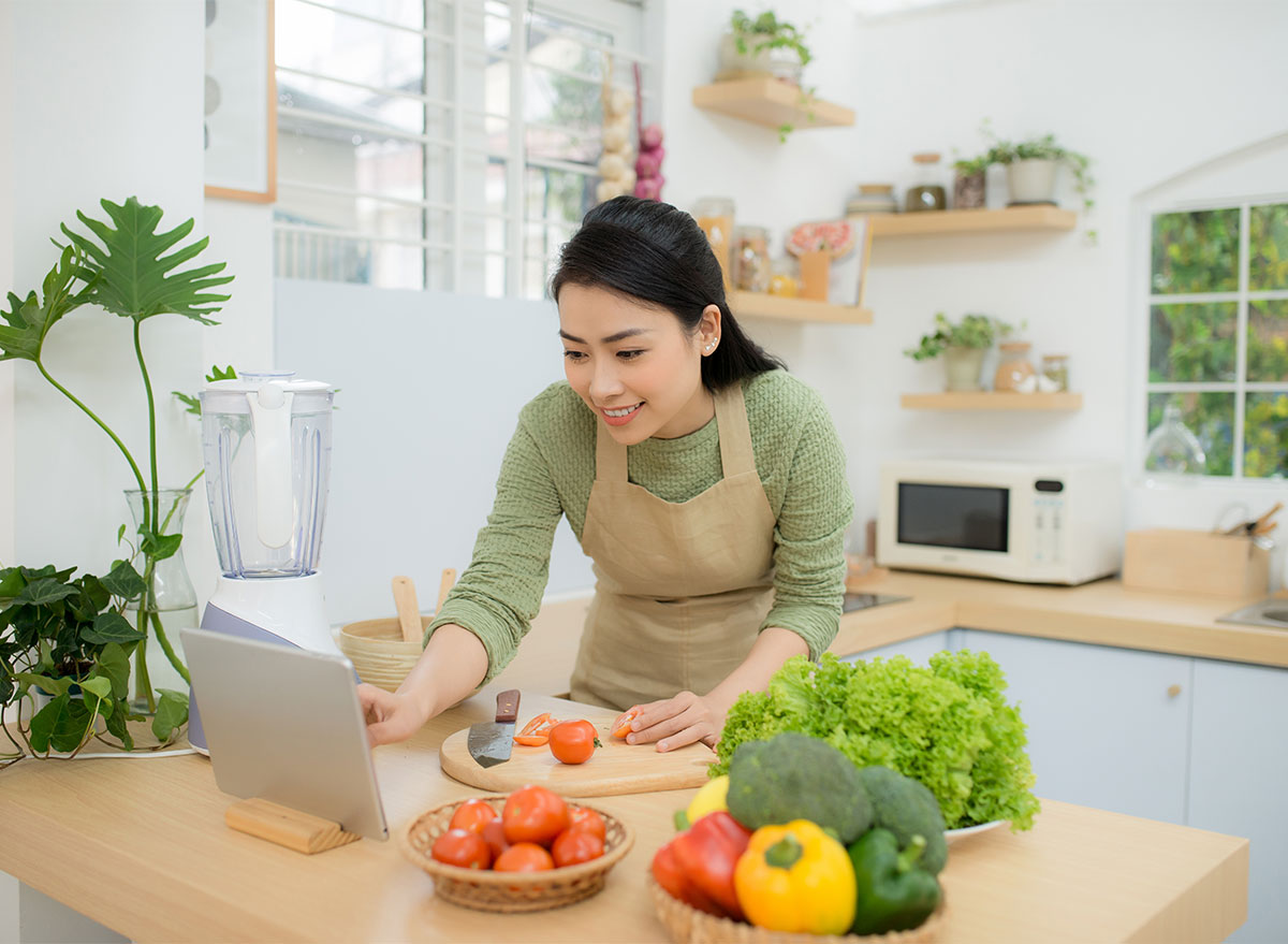 woman cooking with recipe on ipad