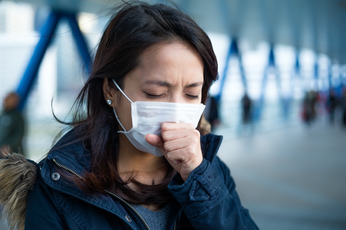 Woman face mask coughing airport