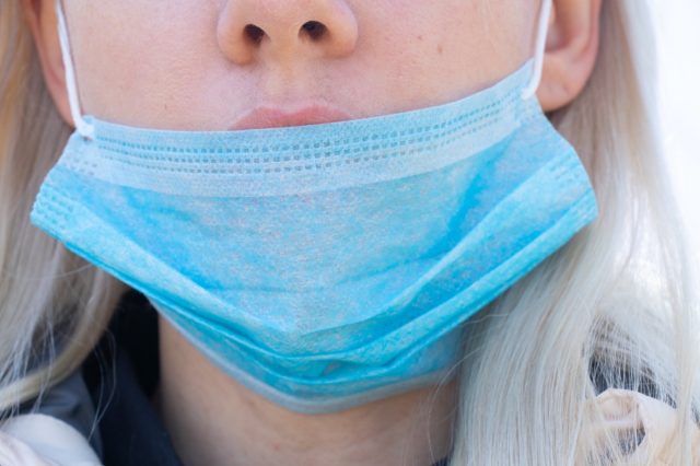 woman in a medical mask on her face during the pandemic outdoors