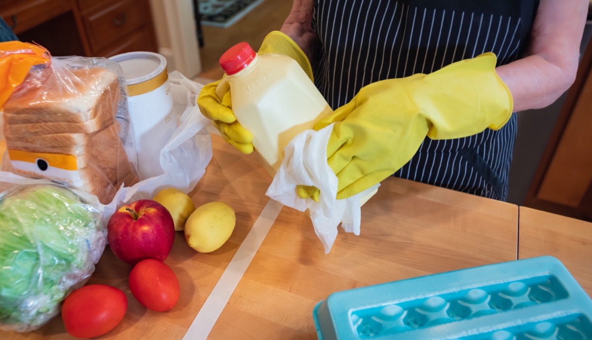 Woman sanitizing cleaning produce items shopping coronavirus kitchen