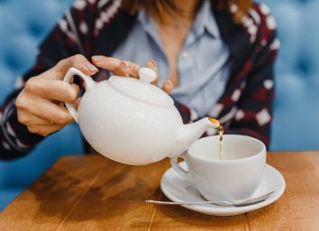 Person pours tea from a kettle close up shot
