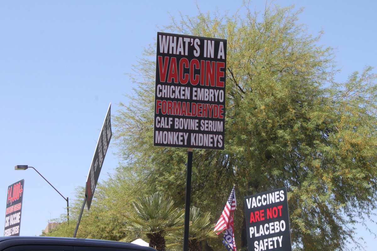 Trump supporters rallying to "reopen" the economy from covid-19 safety restrictions carry signs