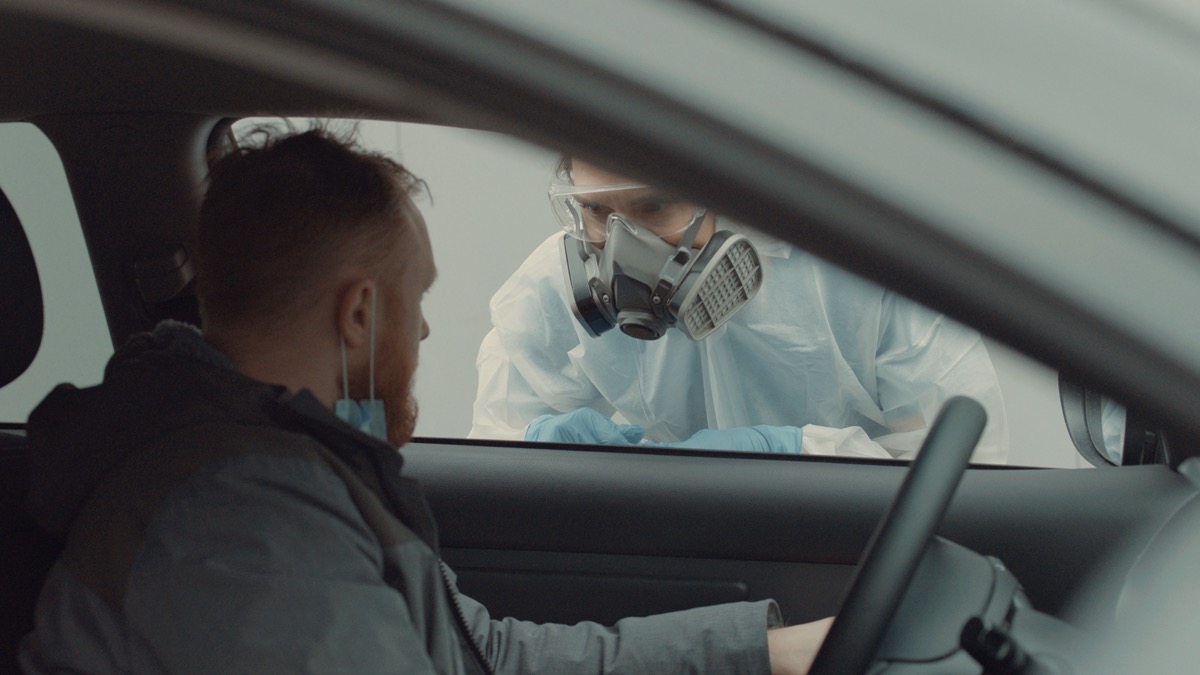 Patient is being tested in his vehicle on a drive-through coronavirus COVID-19 testing location