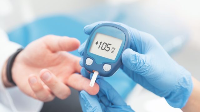 Doctor checking blood sugar level with glucometer. Treatment of diabetes concept.