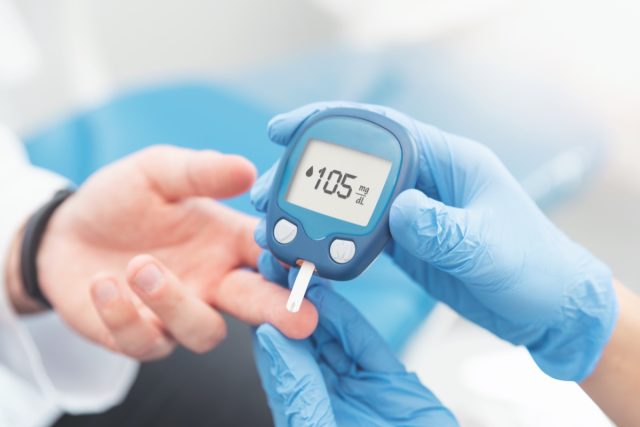 Лекар проверява нивото на кръвната захар с глюкомер.  Концепция за лечение на диабет.