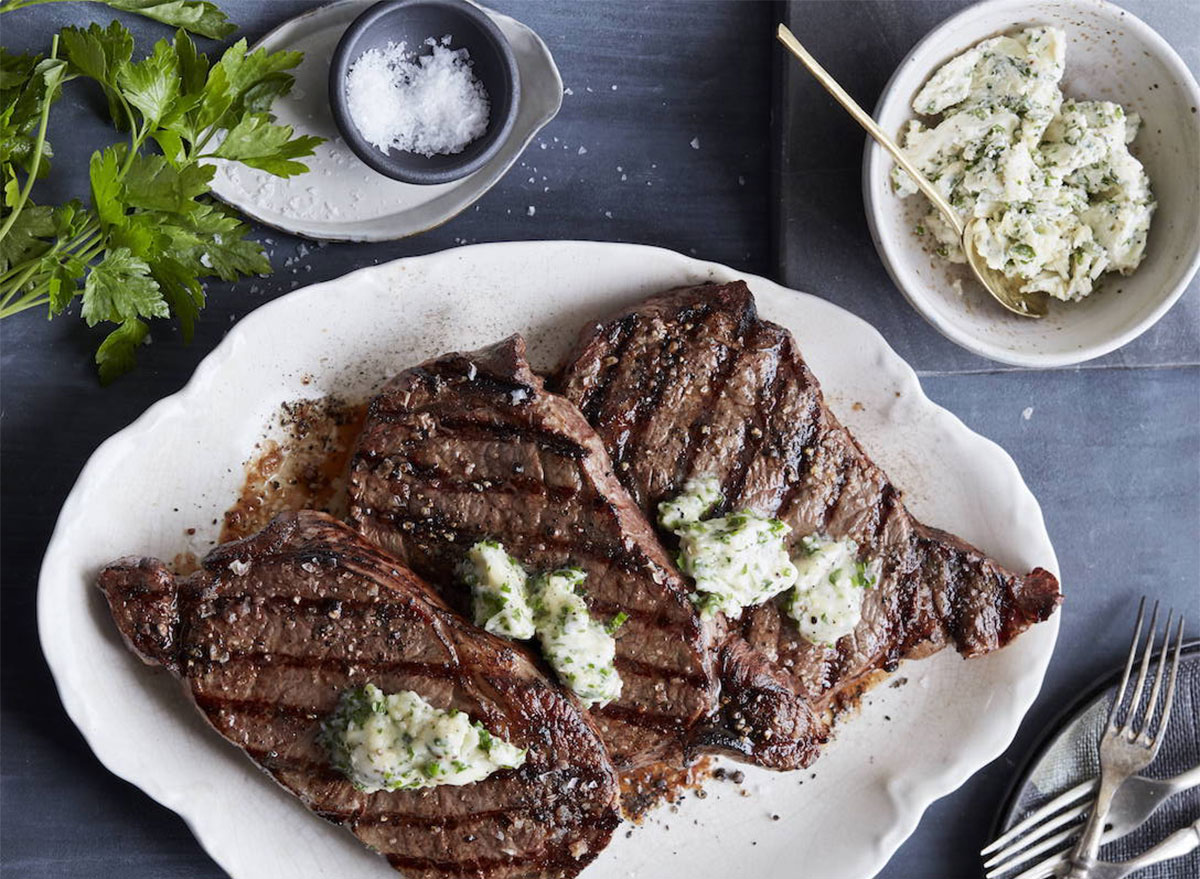 grilled ribeye steaks topped with butter