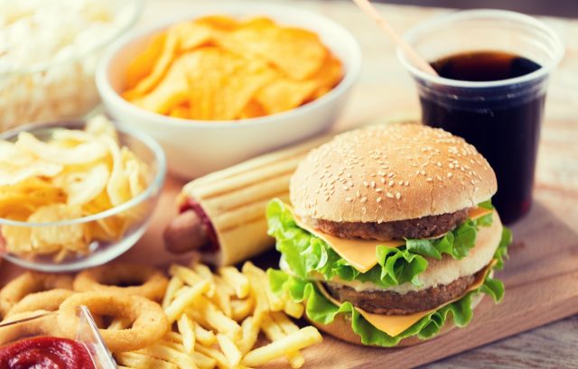 hamburger or cheeseburger, deep-fried squid rings, french fries, drink and ketchup on wooden table