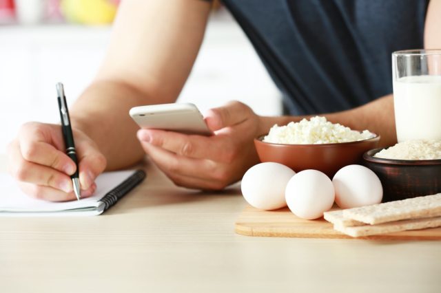 Man counting calories on table