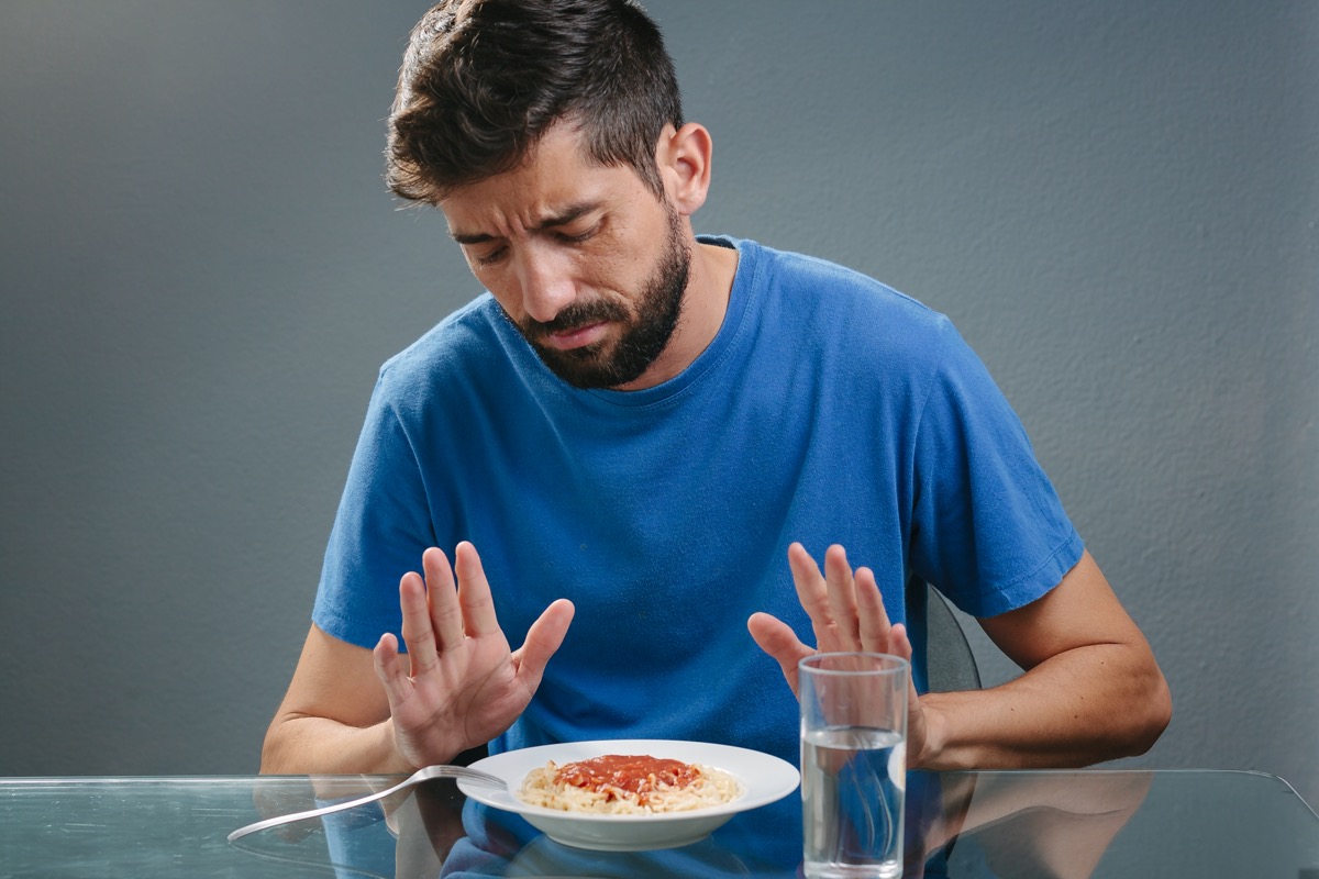 Portrait of man with no appetite in front of the meal