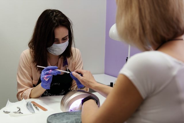 Woman in protective medical mask and manicure.