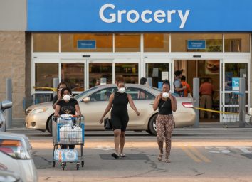 A group of African American ladies wearing protective face masks exit a Wal-Mart amid the COVID-19 epidemic