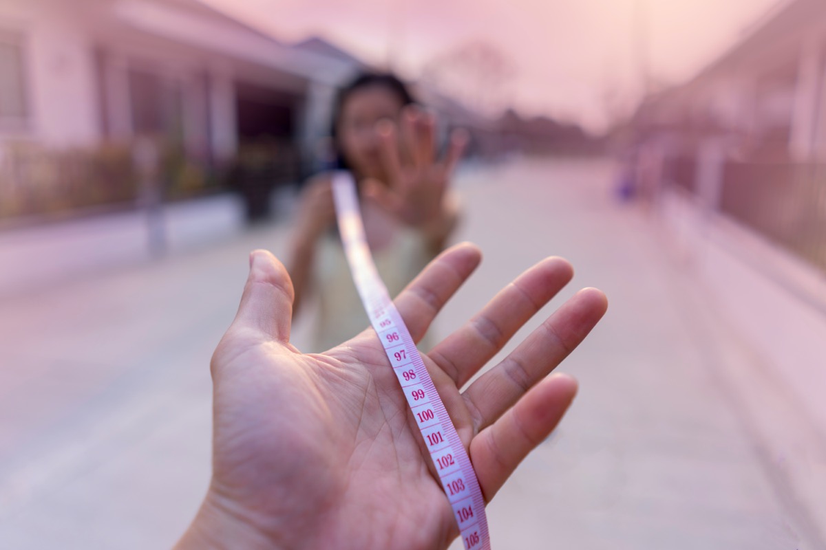 Hand holding Tape measure for safe distance because as a prevention against Coronavirus disease