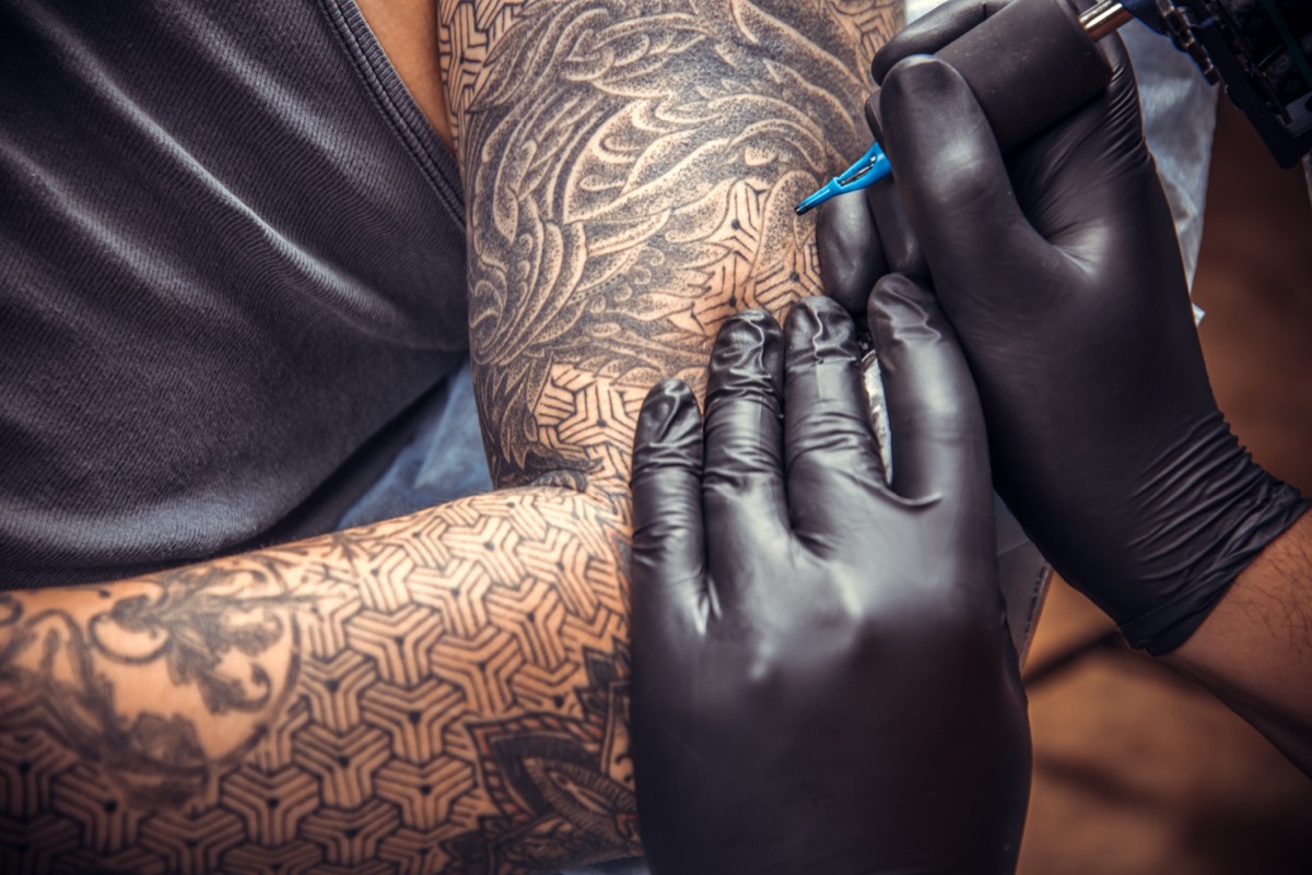 Tattooist posing in tattoo salon.