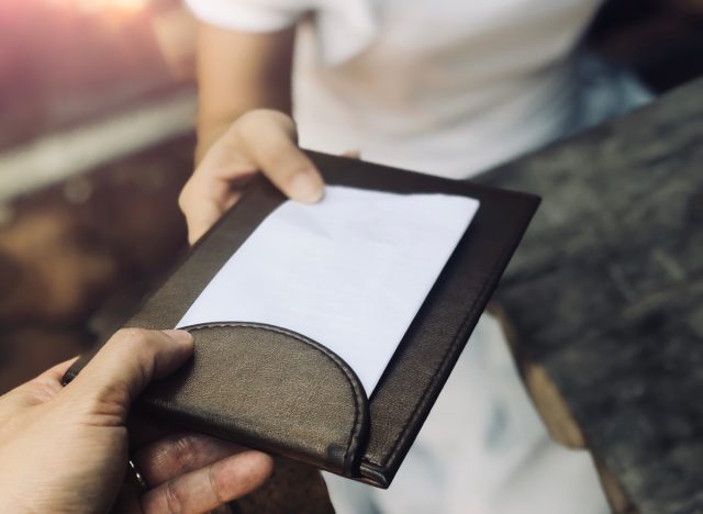 Waiter handing a bill to a customer at a restaurant