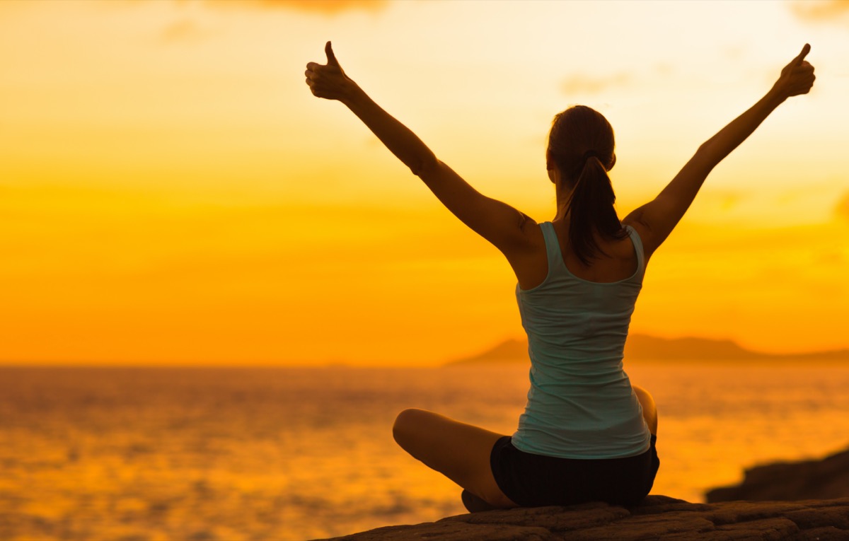 woman celebrating during a beautiful sunset