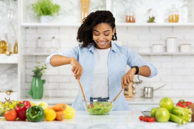 woman preparing vegetable salad in modern kitchen