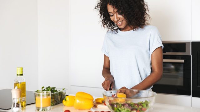 black woman cooking salad