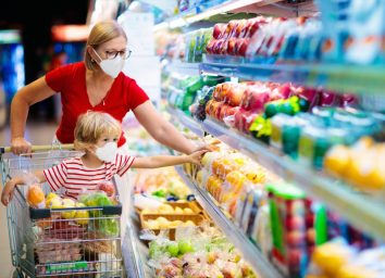 Mom and little boy buy fresh vegetable in grocery store. Family in shop.