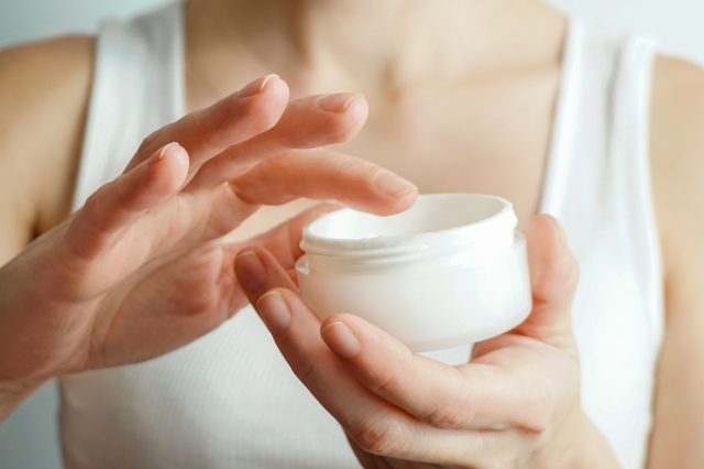 Mujer aplicando crema en la piel