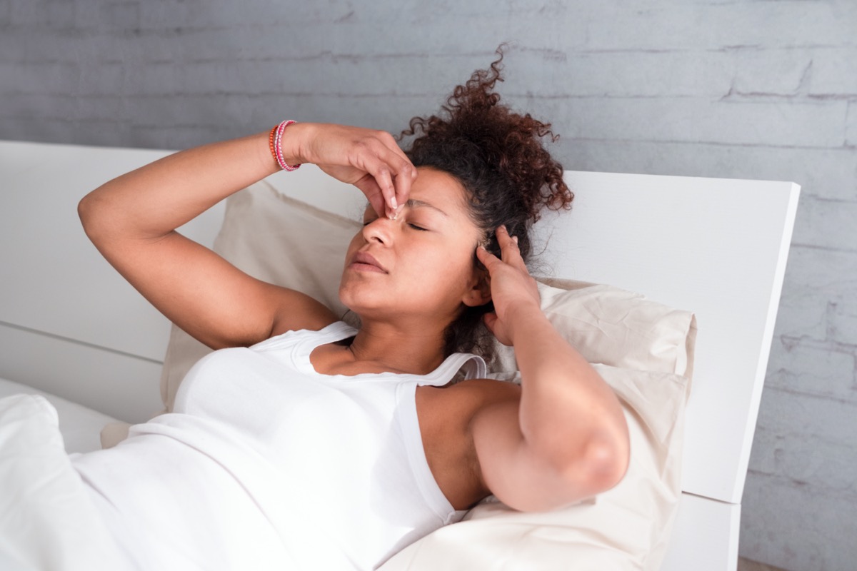 woman feeling sick and uncomfortable in bed