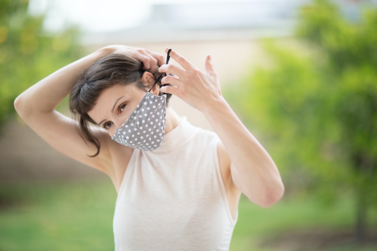 woman put on a fabric handmade mask on her face