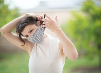 woman put on a fabric handmade mask on her face