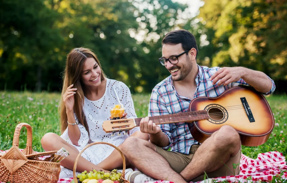 Young couple having fun on picnic in the park