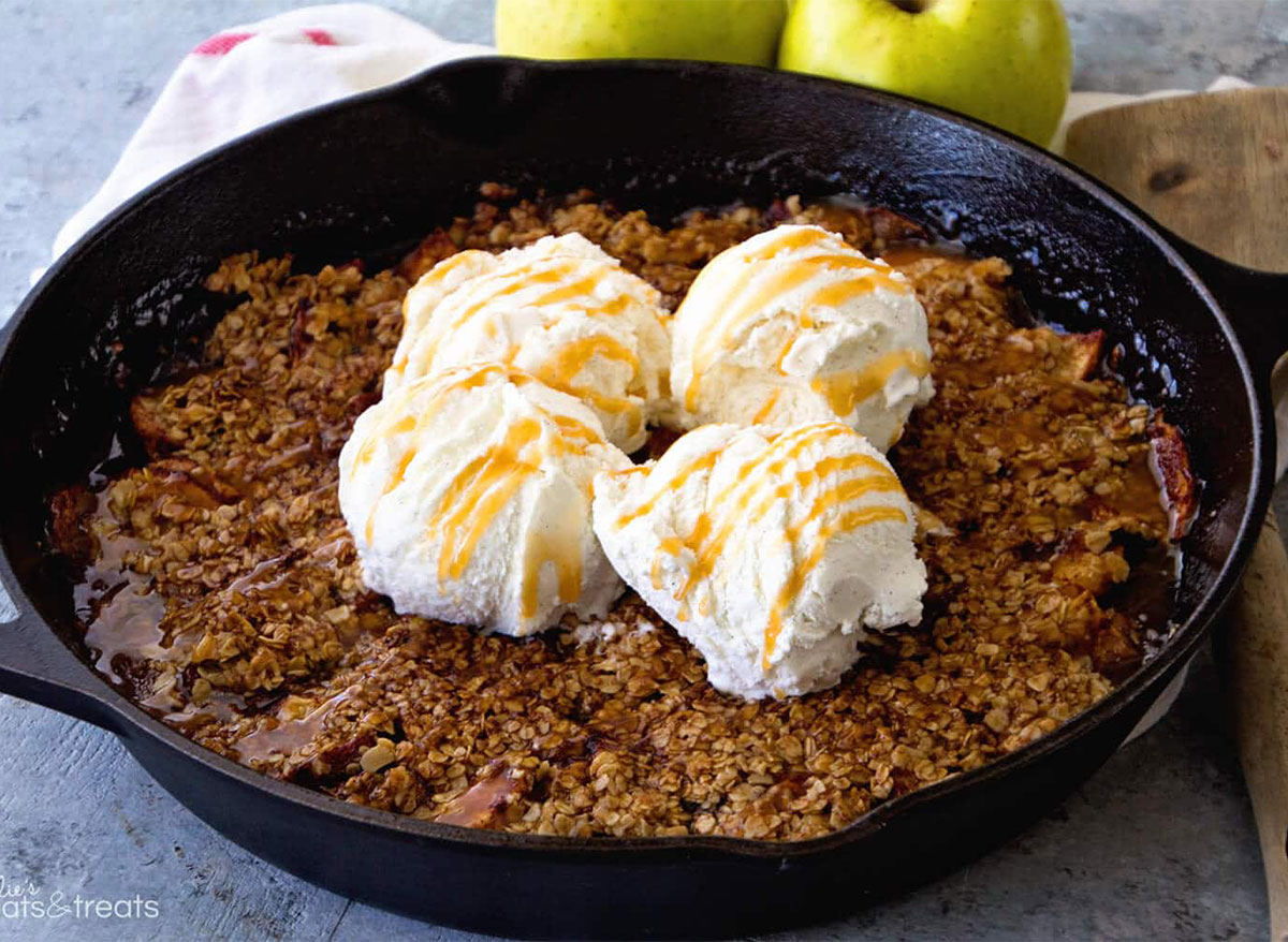 grilled caramel apple crisp in skillet topped with ice cream