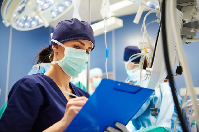 Female nurse examining all the parameters in operating room