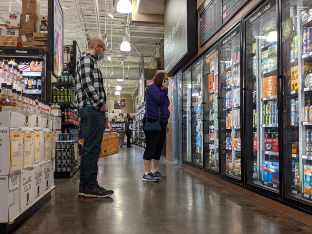 People wearing face masks while shopping for beer and liquor inside a Total Wine and More beverage shop in downtown Bellevue