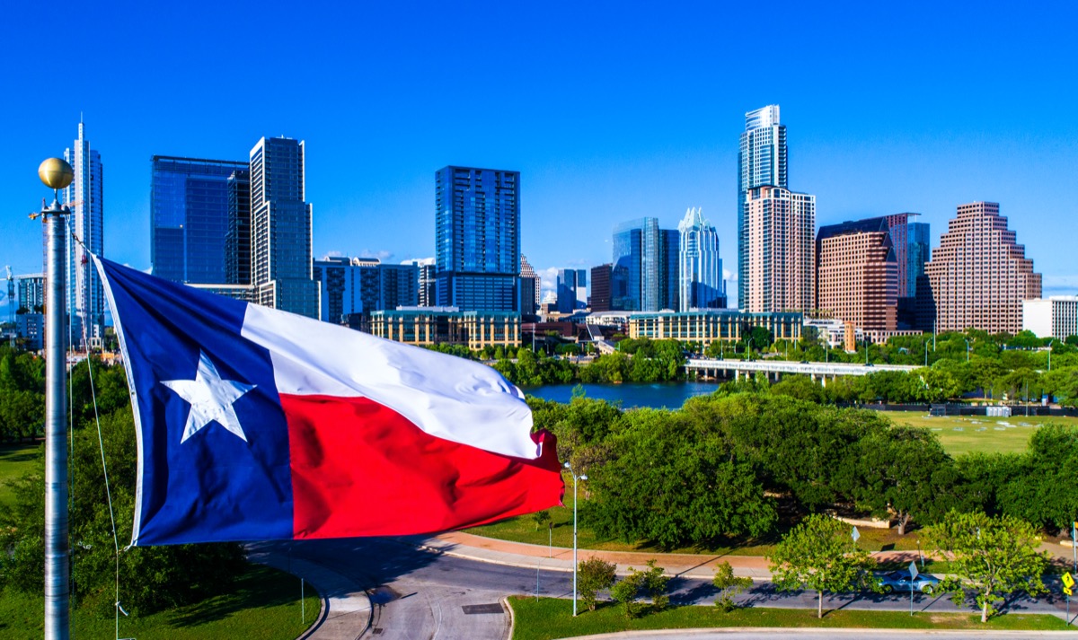Texas Flag waving in front of the Perfect Austin Texas USA Skyline