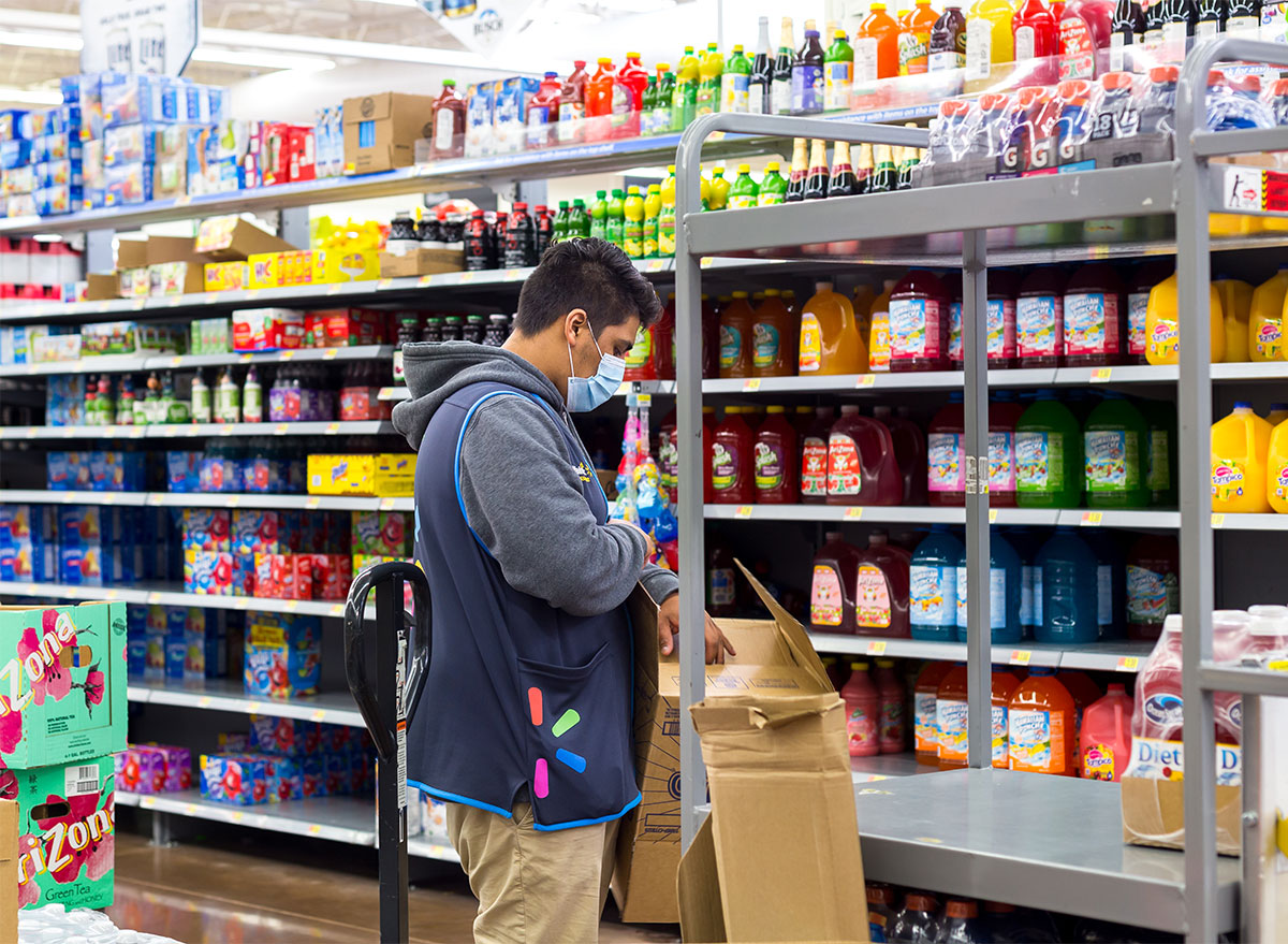 walmart employee in face mask breaking down box